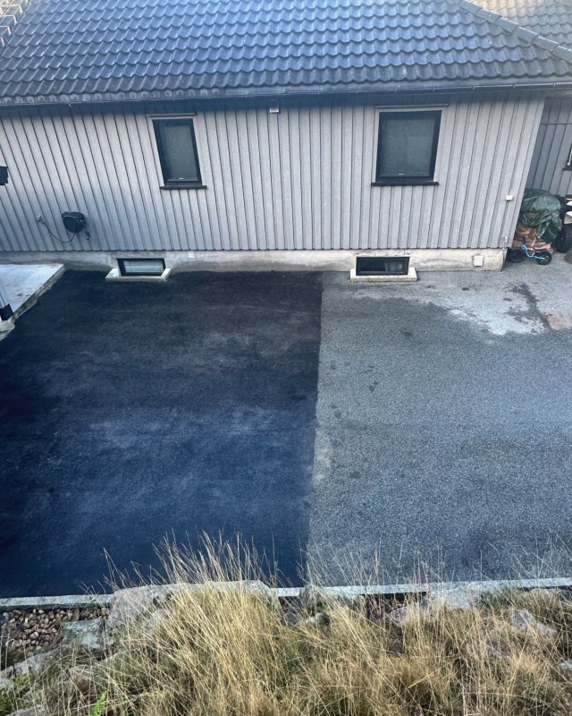 Innkjørsel foran et hus der halve asfalten er fornyet: den ene halvdelen dyp svart, den andre fortsatt grå.